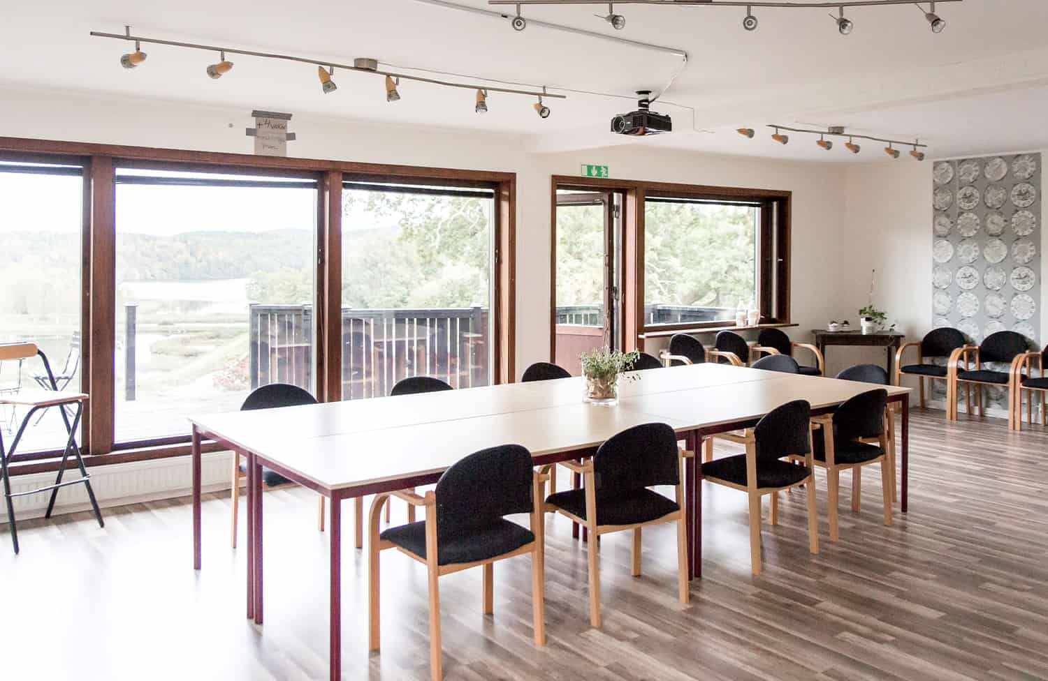 The bright meeting room, "Huset," with large windows and a view of nature