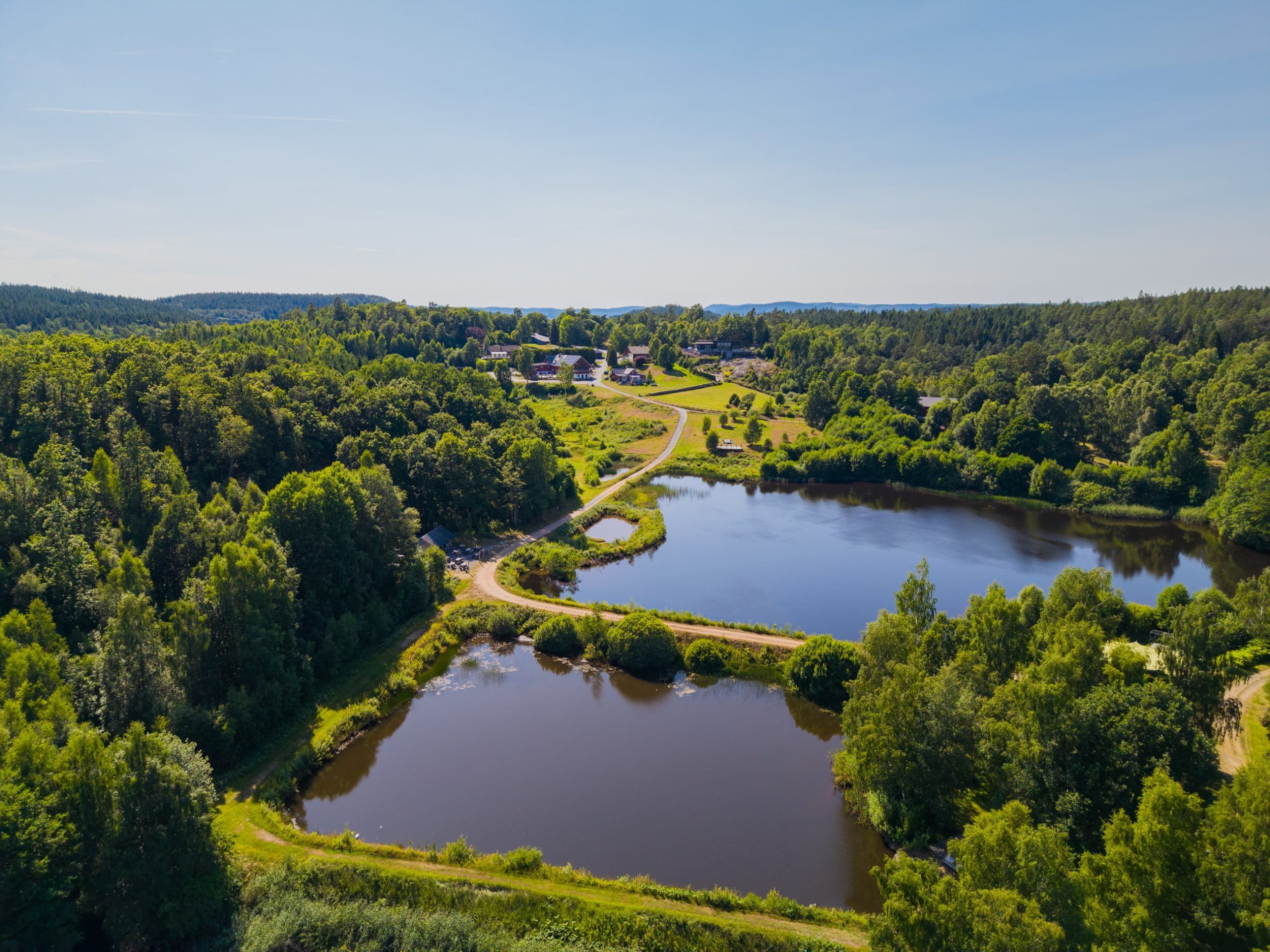 Drone photo of the lakes, the forest, and the farm at Sju Sjöar